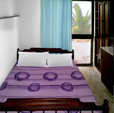 a bedroom with a purple bed with a window at Apartmani Ulcinj Mirza in Ulcinj