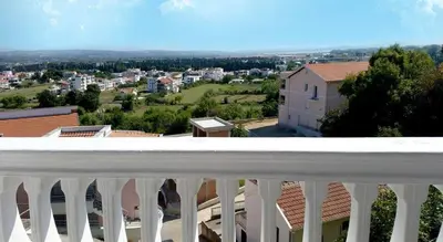 a white balcony with a view of a city at Apartmani Ulcinj Mirza in Ulcinj