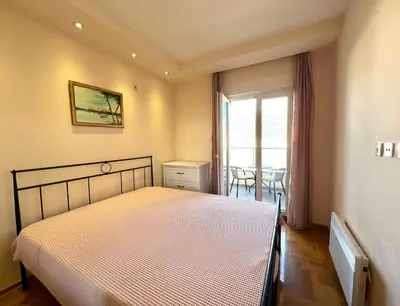 a bedroom with a bed and a window with a table at Apartment Verdan in Bar