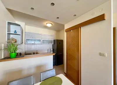 a kitchen and dining room with a table and chairs at Apartment Verdan in Bar