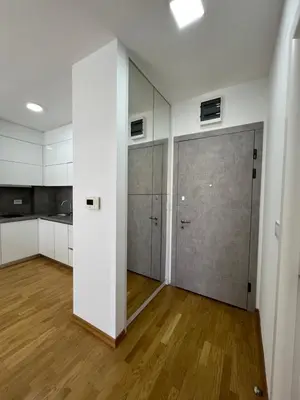 a kitchen with white cabinets and a large door at Tre Sorelle Becici in Becici
