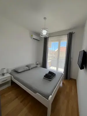 a bedroom with a large bed with a window at Tre Sorelle Becici in Becici