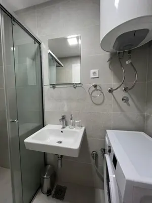 a bathroom with a sink and a shower and a mirror at Tre Sorelle Becici in Becici