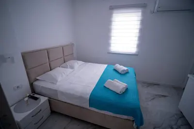 a bedroom with a bed and a sink and a window at Apartmani Nevena Airport in Mitrovići