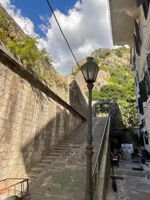 a street light next to a stone wall with stairs at Balcony with Old Town view in Kotor