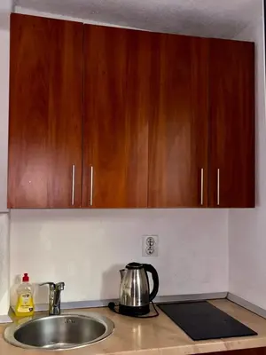 a kitchen counter with a sink and wooden cabinets at Balcony with Old Town view in Kotor