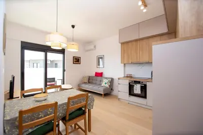 a kitchen and living room with a table and a couch at Adriatic calm Terrace & Parking in Becici