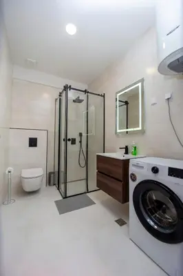 a bathroom with a washing machine and a toilet at Adriatic calm Terrace & Parking in Becici