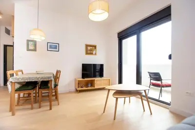 a living room with a table and chairs and a tv at Adriatic calm Terrace & Parking in Becici