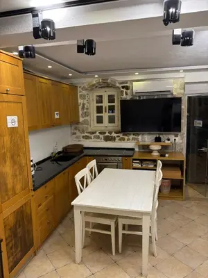 a kitchen with a white table and a tv at sar 1 balcony in Kotor