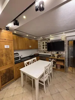 a kitchen with a white table and a tv at sar 1 balcony in Kotor