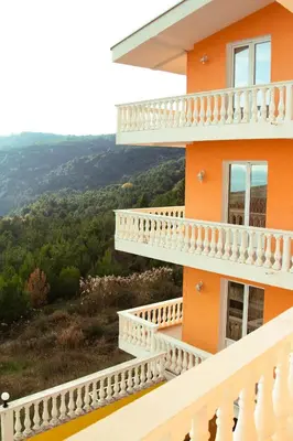 an orange house with a balcony with a view at Vila Kraljica Snežna in Kravlja
