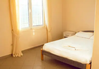a small bedroom with a bed and a window at Vila Kraljica Snežna in Kravlja