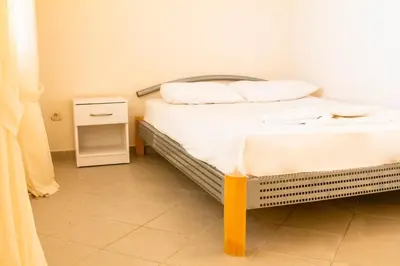 a bedroom with a bed with white sheets and pillows at Vila Kraljica Snežna in Kravlja