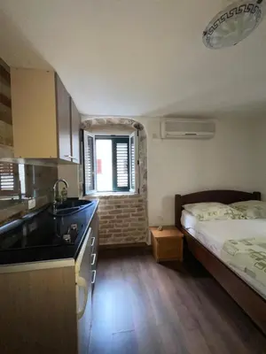 a kitchen with a bed and a sink in a room at sar 4 in Kotor