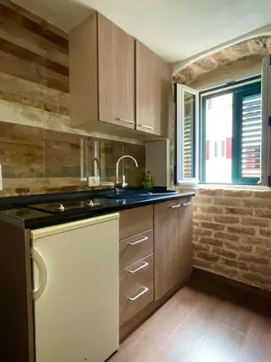 a kitchen with wooden cabinets and a sink and a window at sar 5 in Kotor