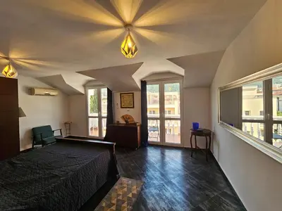 a bedroom with a large bed and a large window at Charming Central Flat - Balcony with Mountain View, Near Beach in Budva