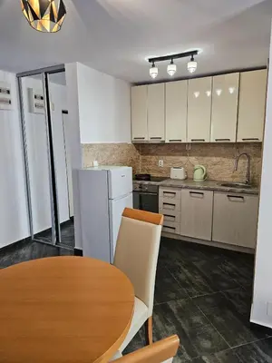 a kitchen with a table and a white refrigerator at Charming Central Flat - Balcony with Mountain View, Near Beach in Budva