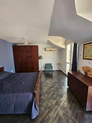 a bedroom with a bed and a chair in a room at Charming Central Flat - Balcony with Mountain View, Near Beach in Budva