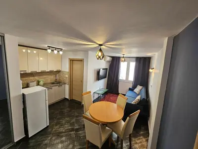 a kitchen and a dining room with a table in a room at Charming Central Flat - Balcony with Mountain View, Near Beach in Budva