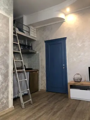 a room with a ladder and a blue door at Lucky Space 1 Nice&Cosy Studio in Budva