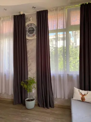 a living room with curtains and a plant in front of a window at Lucky Space 1 Nice&Cosy Studio in Budva