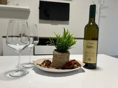 a table with a bottle of wine and two wine glasses at Apartment Brijest-Kotor in Kotor