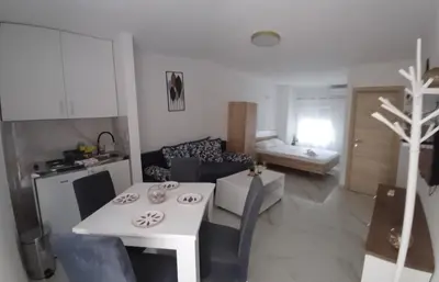 a kitchen and a living room with a white table at Apartment Brijest-Kotor in Kotor