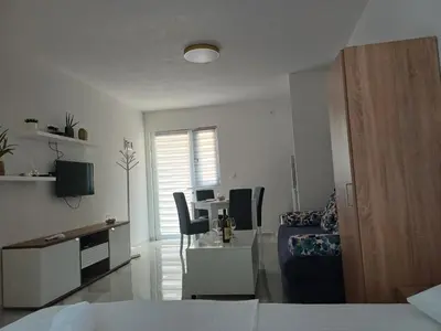 a living room with a bed and a table and chairs at Apartment Brijest-Kotor in Kotor