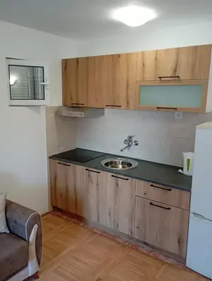 a kitchen with wooden cabinets and a sink at Walk to the Sea-1 bedroom BUDVA in Budva