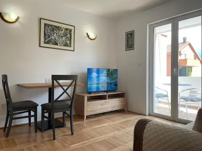 a living room with a television and a table and chairs at Walk to the Sea-1 bedroom BUDVA in Budva