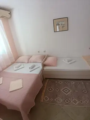 two beds in a room with pink sheets at Pet Friendly Apartment Ground Floor in Petrovac na Moru