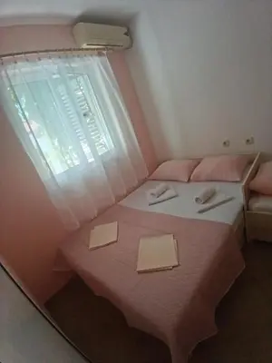 a bedroom with a pink bed with a window at Pet Friendly Apartment Ground Floor in Petrovac na Moru