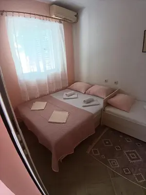 a small room with two beds and a window at Pet Friendly Apartment Ground Floor in Petrovac na Moru