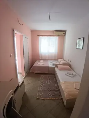 two beds in a room with a window at Pet Friendly Apartment Ground Floor in Petrovac na Moru