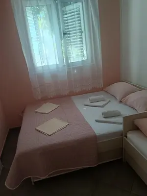 a bed with two pillows and a window at Pet Friendly Apartment Ground Floor in Petrovac na Moru