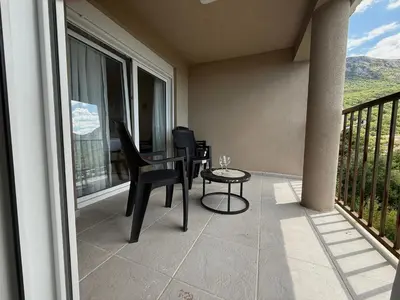 a balcony with a table and a chair on a balcony at Sunset Serenade Apartment