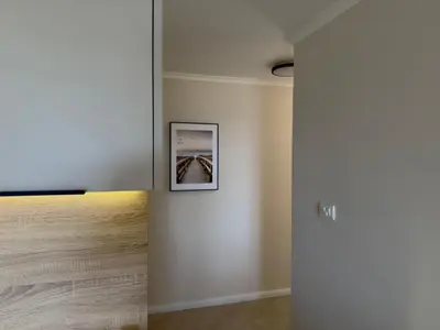 a room with a wall with a picture on it at Sunset Serenade Apartment