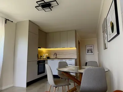 a kitchen and dining room with a table and chairs at Sunset Serenade Apartment
