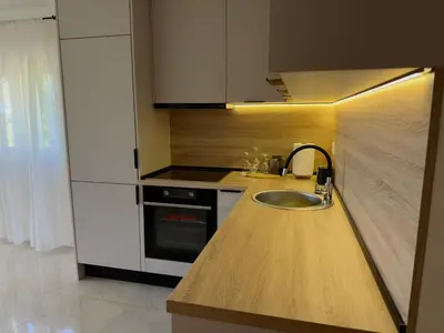 a kitchen with a sink and a stove at Sunset Serenade Apartment