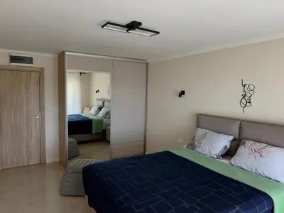 a bedroom with a blue bed and a mirror at Sunset Serenade Apartment