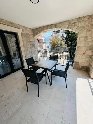 a table and chairs on a patio with a balcony at Sunny Bay Apartments in Budva