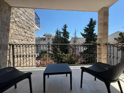 two chairs and a table on a balcony with a fence at Sunny Bay Apartments in Budva