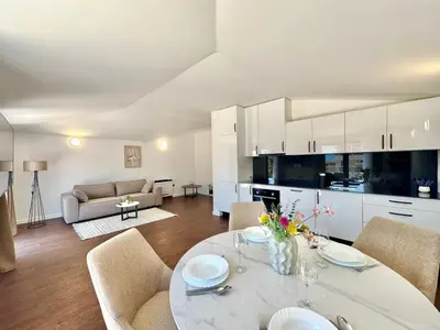 a kitchen and living room with a table and chairs at Sunny Bay Apartments in Budva