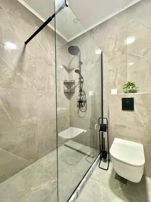 a bathroom with a toilet and a glass shower at Sunny Bay Apartments in Budva