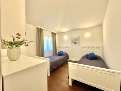 a bedroom with two beds and a vase of flowers at Sunny Bay Apartments in Budva