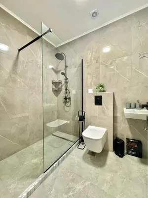 a bathroom with a glass shower and a toilet at Sunny Bay Apartments in Budva