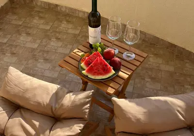 a table with a plate of fruit and a bottle of wine at Montehome sea view in Becici