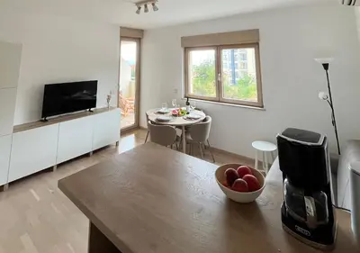 a living room with a kitchen with a table and a television at Montehome sea view in Becici