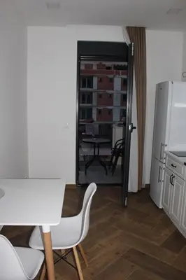 a kitchen with a table and chairs and a refrigerator at AMD - garsonjera 312 in Dobra Voda